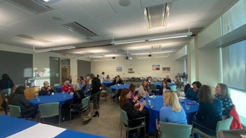 a conference room filled with women sitting at round tables of 8